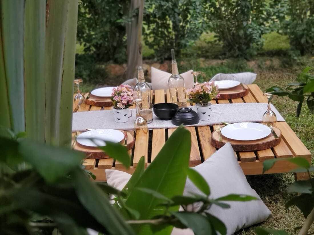 Picnic table set among the greenery at Ampumuzza
